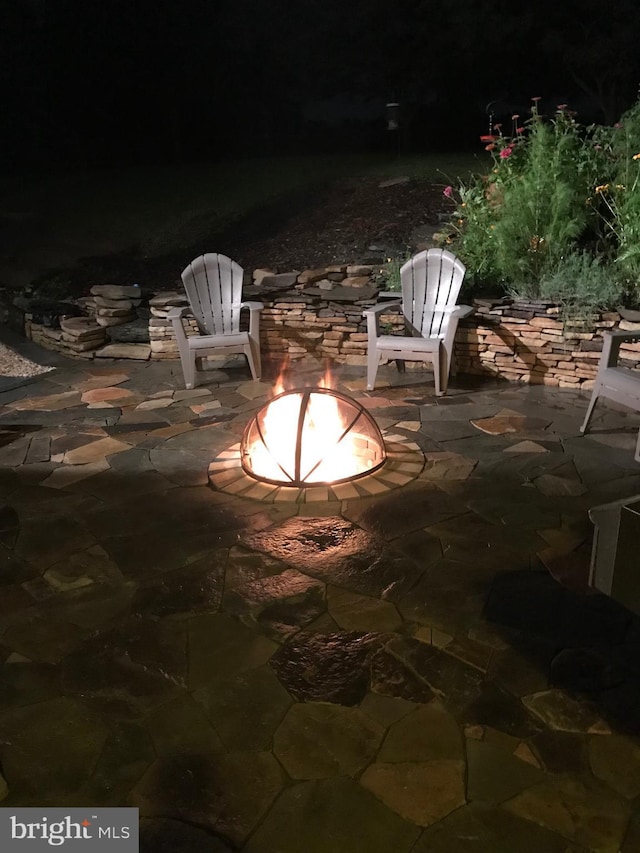 patio at night featuring a fire pit