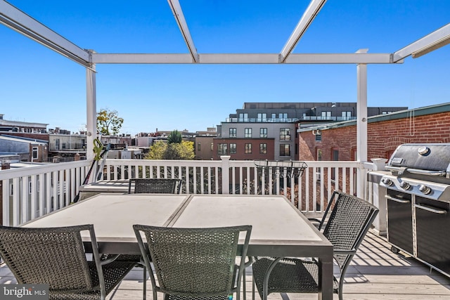 wooden terrace featuring area for grilling and a pergola