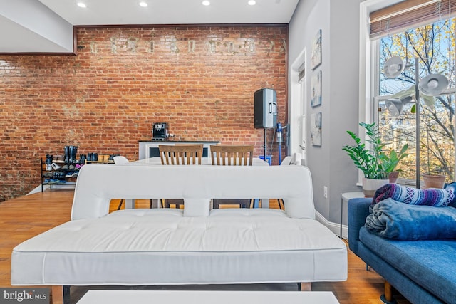 dining area with hardwood / wood-style flooring and brick wall