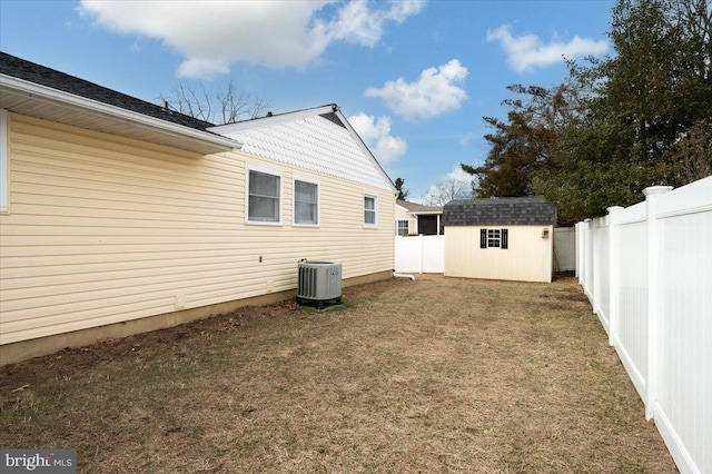 exterior space with a yard, a shed, and central AC