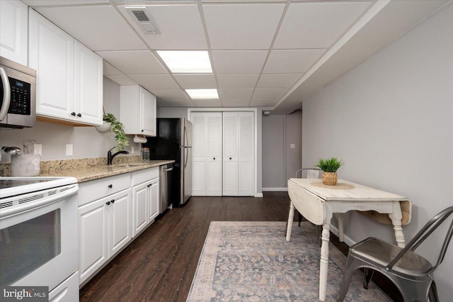 kitchen with white cabinetry, sink, a paneled ceiling, appliances with stainless steel finishes, and dark hardwood / wood-style floors