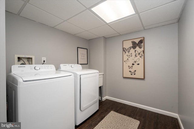 clothes washing area with dark wood-type flooring and washer and clothes dryer