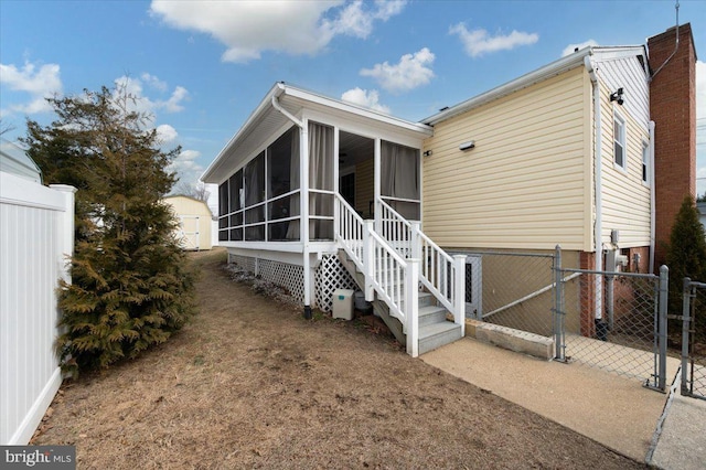 rear view of property featuring a sunroom