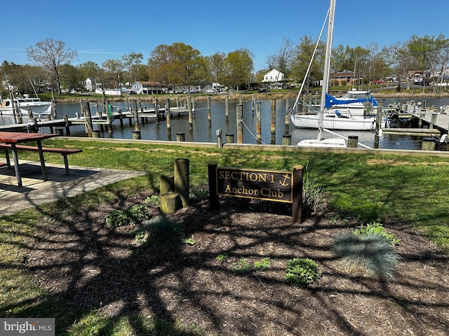 view of dock with a yard and a water view