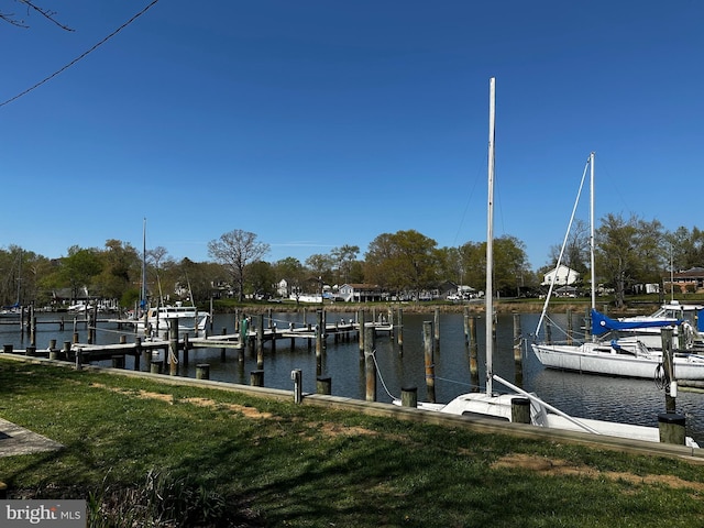 view of dock with a yard and a water view