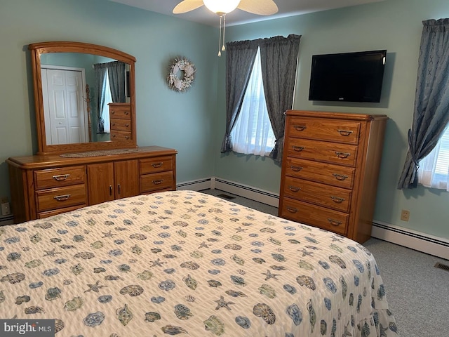 bedroom with a baseboard heating unit, a closet, ceiling fan, and carpet flooring