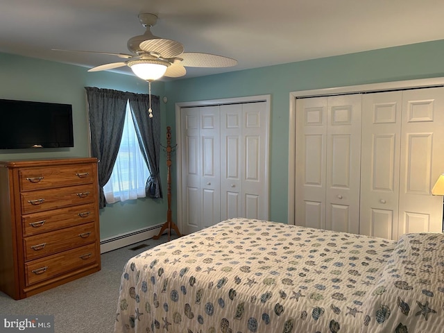 bedroom with light carpet, a baseboard heating unit, two closets, and ceiling fan