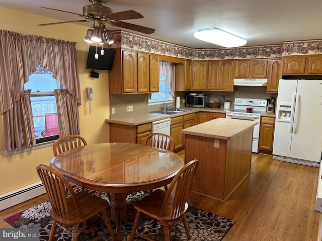 kitchen with sink, dark hardwood / wood-style floors, a kitchen island, white appliances, and a baseboard heating unit