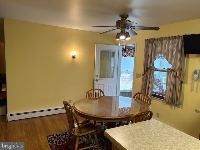 dining space with wood-type flooring, ceiling fan, and baseboard heating