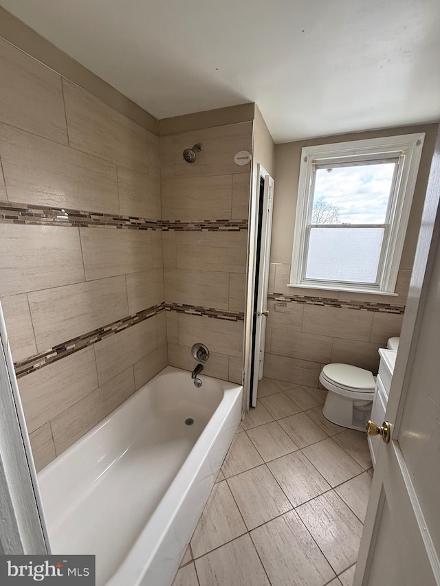 full bathroom with toilet, tiled shower / bath, tile walls, vanity, and tile patterned flooring