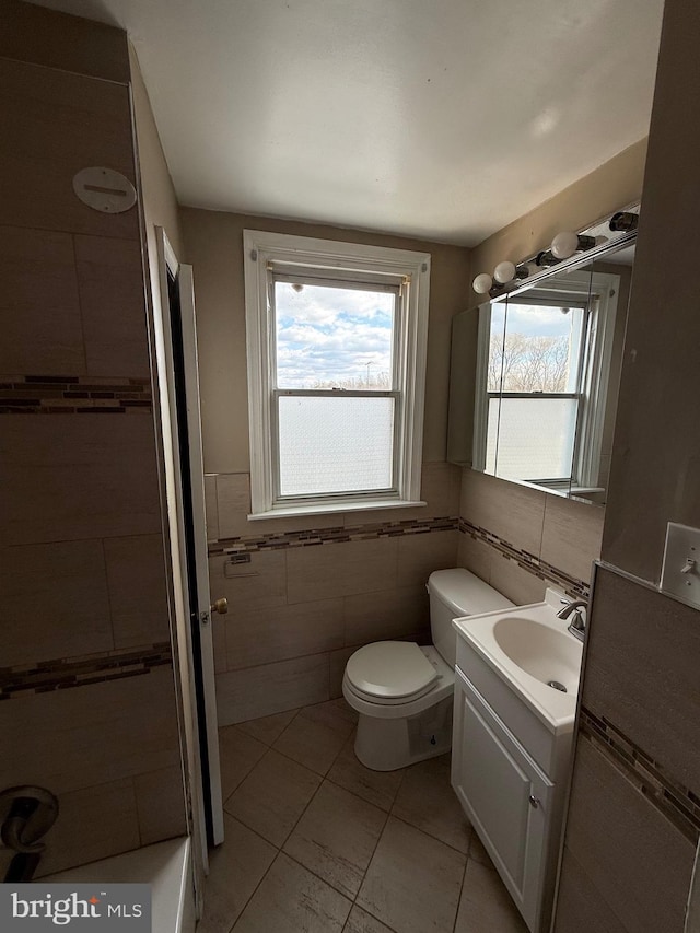 bathroom with tile patterned flooring, vanity, tile walls, and toilet