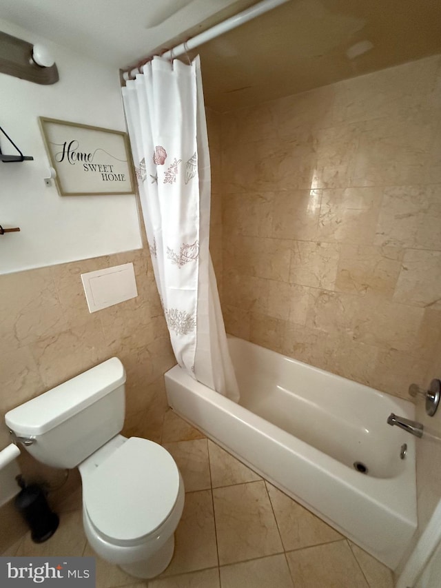 bathroom with toilet, tile walls, and shower / bath combo with shower curtain