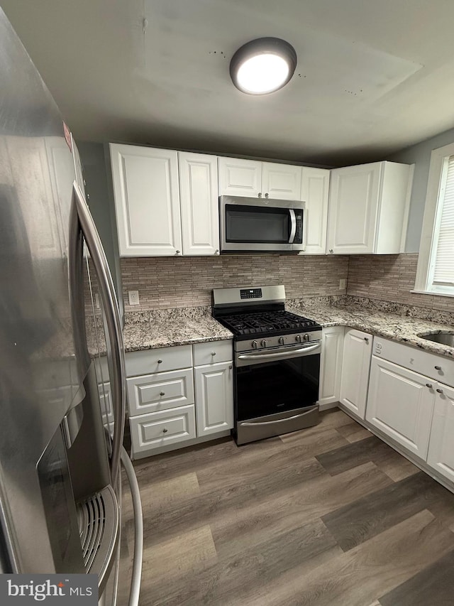 kitchen featuring white cabinetry, stainless steel appliances, and dark hardwood / wood-style floors