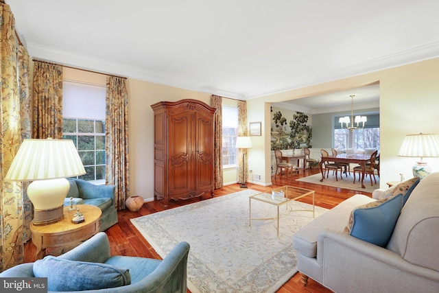 living room featuring crown molding, a notable chandelier, and hardwood / wood-style flooring