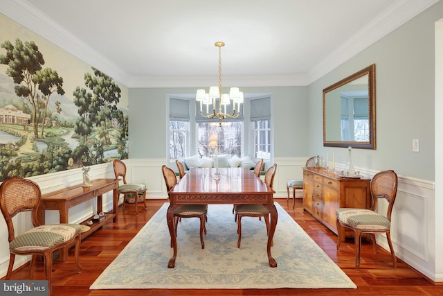 dining area with crown molding, wood-type flooring, and a chandelier