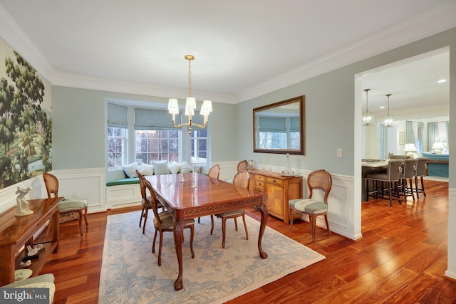 dining room with an inviting chandelier, crown molding, and hardwood / wood-style flooring