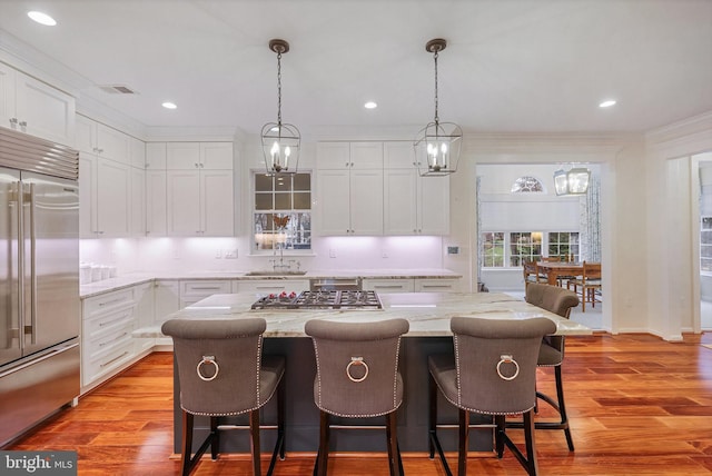 kitchen with sink, stainless steel appliances, a kitchen breakfast bar, and a kitchen island