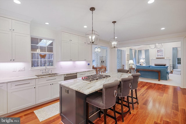 kitchen with sink, stainless steel appliances, white cabinets, and a kitchen island