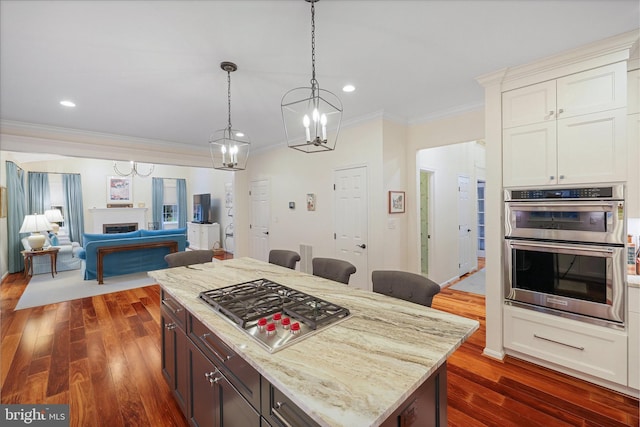 kitchen featuring stainless steel appliances, dark hardwood / wood-style floors, white cabinets, and a kitchen island