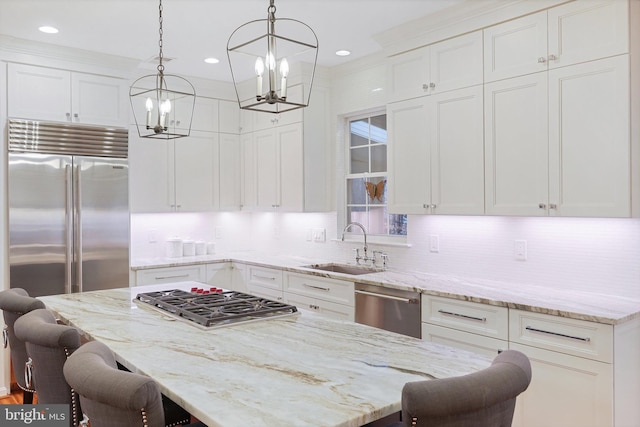 kitchen with decorative light fixtures, stainless steel appliances, a breakfast bar, and white cabinets