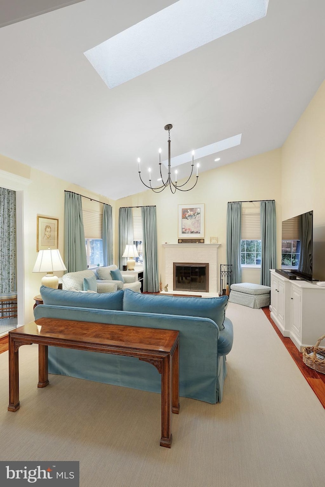 living room with vaulted ceiling with skylight and a notable chandelier