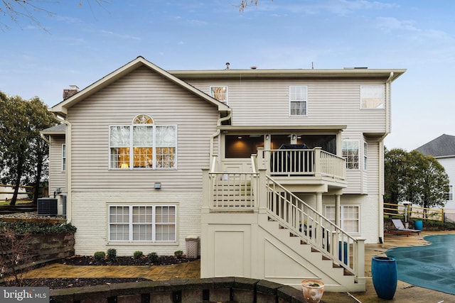 back of property with a covered pool and cooling unit