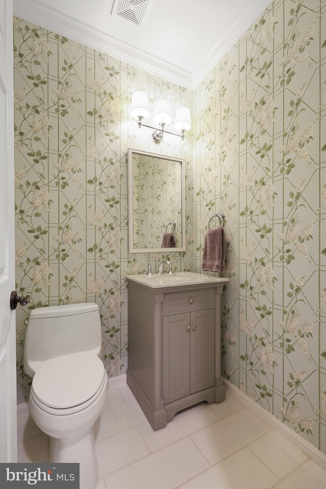 bathroom featuring tile patterned flooring, ornamental molding, vanity, and toilet