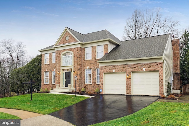 view of front of house featuring a garage and a front lawn