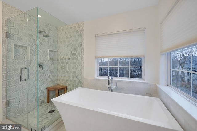 bathroom featuring plenty of natural light and separate shower and tub