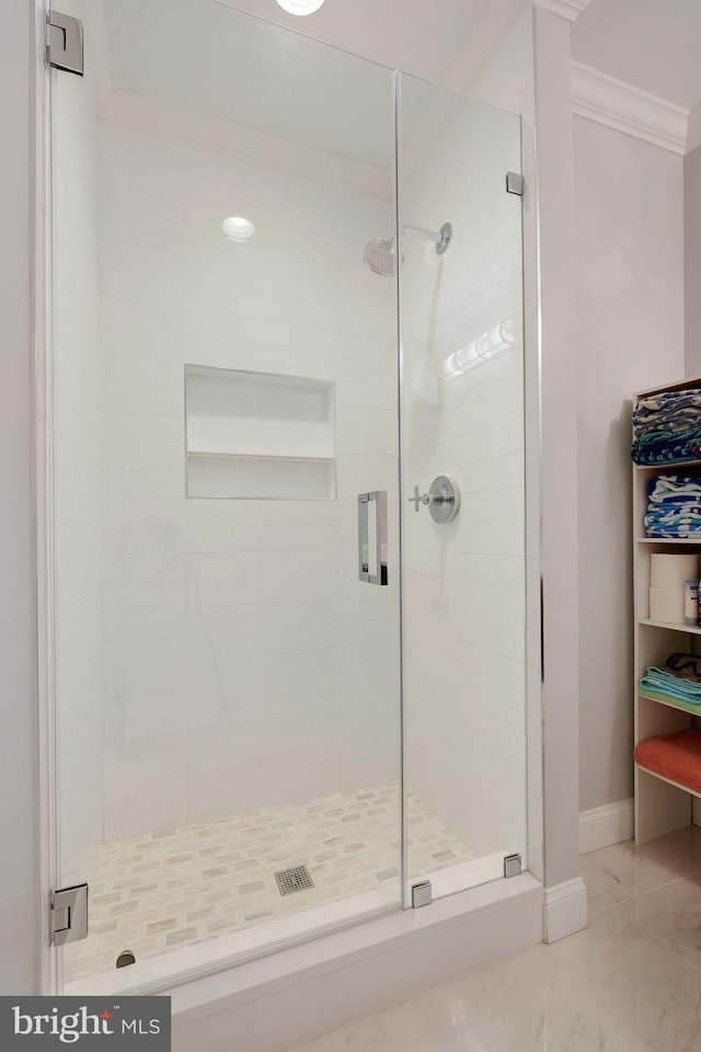 bathroom with an enclosed shower and ornamental molding