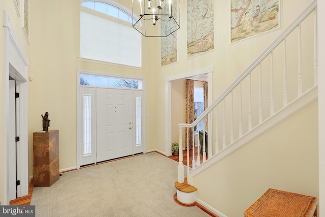 entryway featuring a notable chandelier, carpet, and a high ceiling