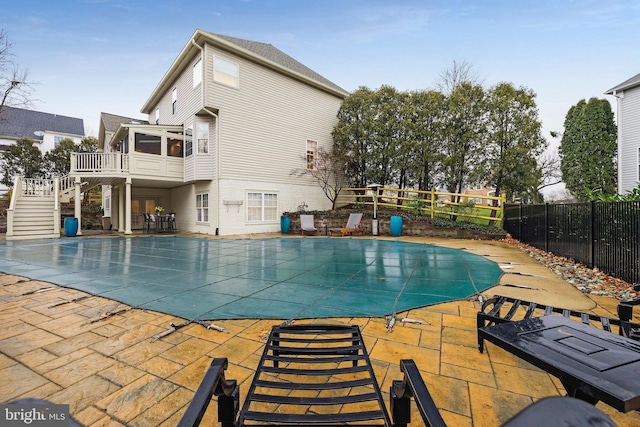 view of swimming pool with a sunroom and a patio