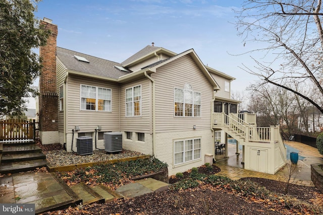 rear view of property with a sunroom, a patio, and central air condition unit