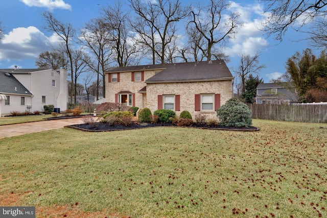 traditional-style house featuring a front lawn and fence