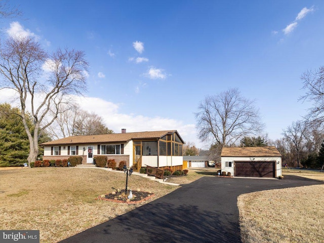 view of front of house with a garage, a sunroom, and a front yard