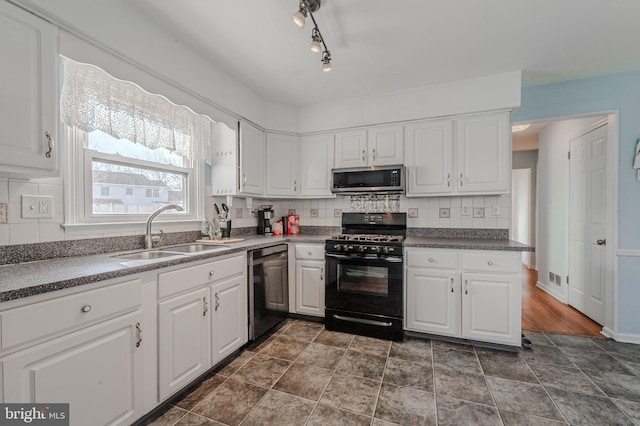 kitchen with dishwashing machine, sink, black gas stove, white cabinets, and decorative backsplash