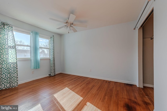 unfurnished bedroom featuring ceiling fan, hardwood / wood-style floors, and a closet