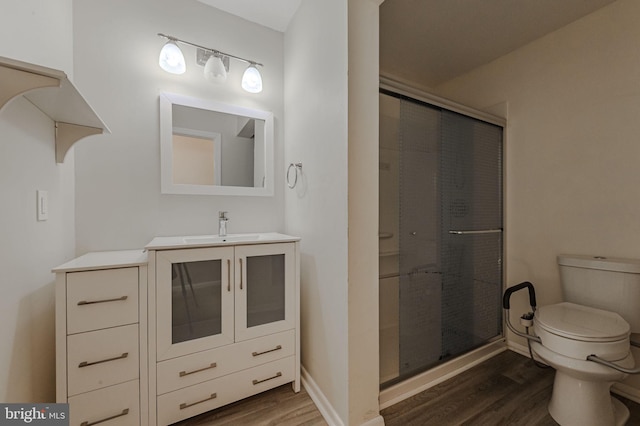 bathroom featuring an enclosed shower, hardwood / wood-style floors, vanity, and toilet