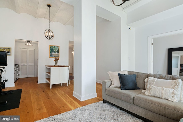 living room featuring brick ceiling, a chandelier, and light hardwood / wood-style floors