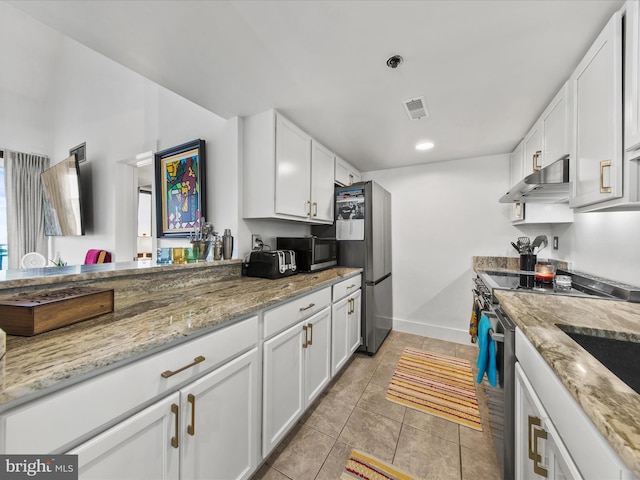 kitchen featuring white cabinetry, light stone counters, light tile patterned flooring, and appliances with stainless steel finishes