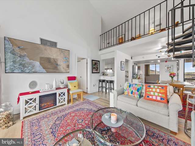 living room with a high ceiling and light hardwood / wood-style floors