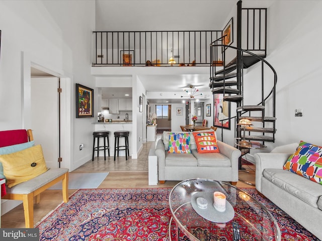 living room featuring a towering ceiling and light hardwood / wood-style flooring