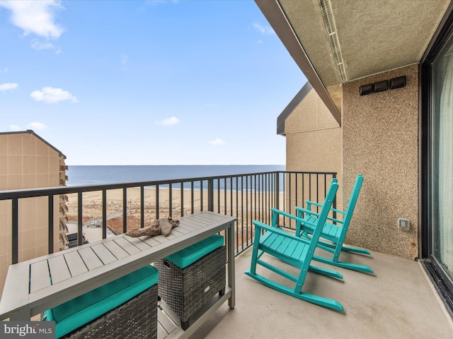 balcony with a water view and a view of the beach