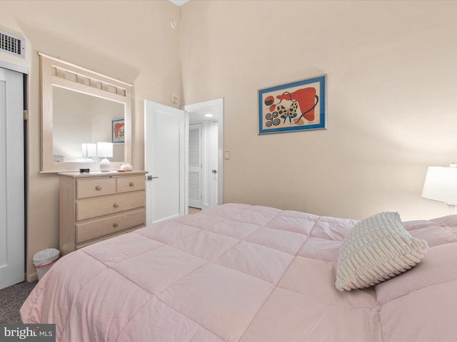 bedroom featuring a towering ceiling and carpet