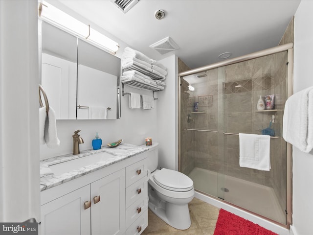 bathroom featuring tile patterned flooring, toilet, vanity, and a shower with shower door