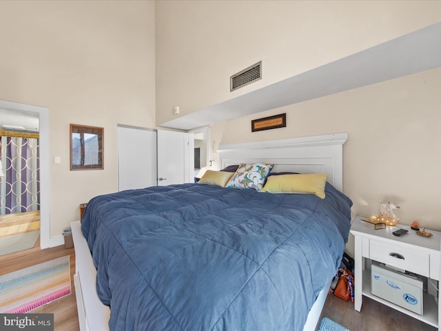 bedroom featuring a high ceiling and dark hardwood / wood-style floors