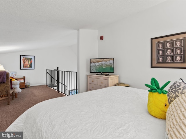 bedroom with carpet flooring, vaulted ceiling, and a textured ceiling