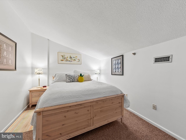 bedroom featuring lofted ceiling, carpet floors, and a textured ceiling