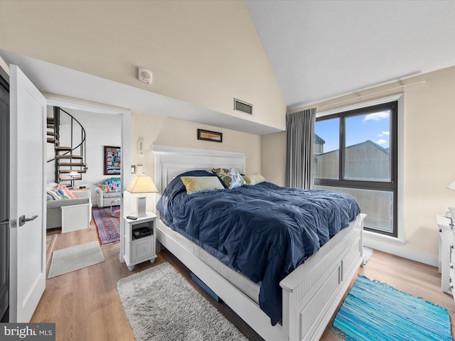 bedroom featuring vaulted ceiling and wood-type flooring