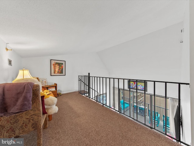 living area featuring lofted ceiling, carpet floors, and a textured ceiling